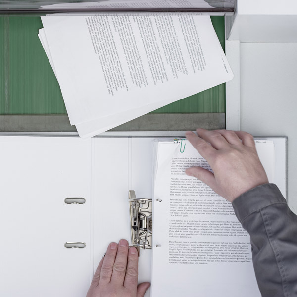 persons hands placing paper in paper shredder
